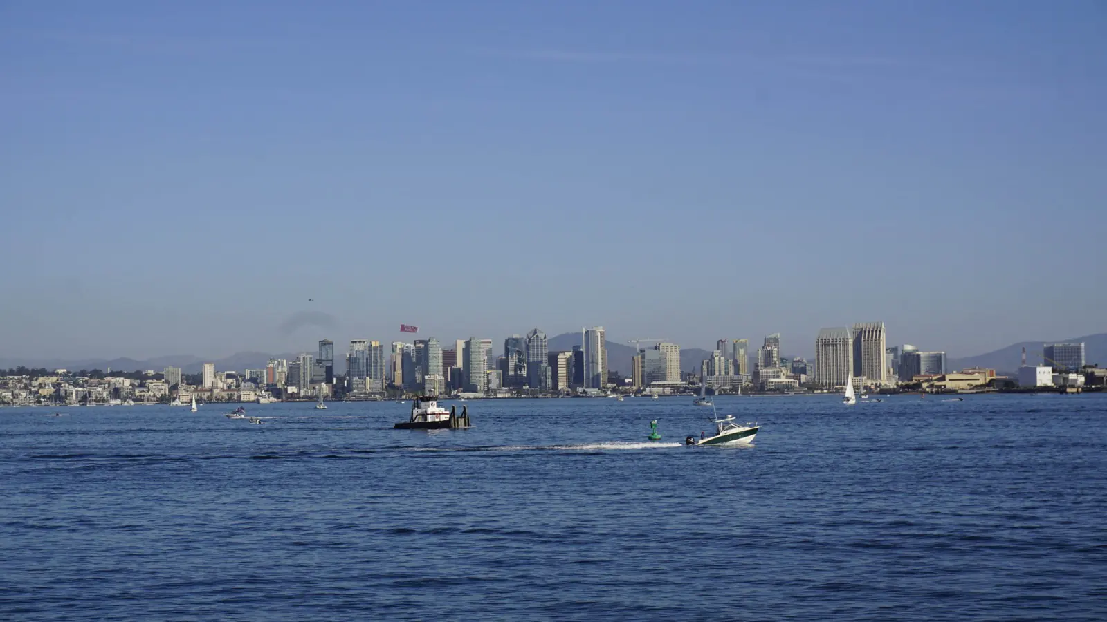 The San Diego skyline seen across the bay, small boats on the water in front of it